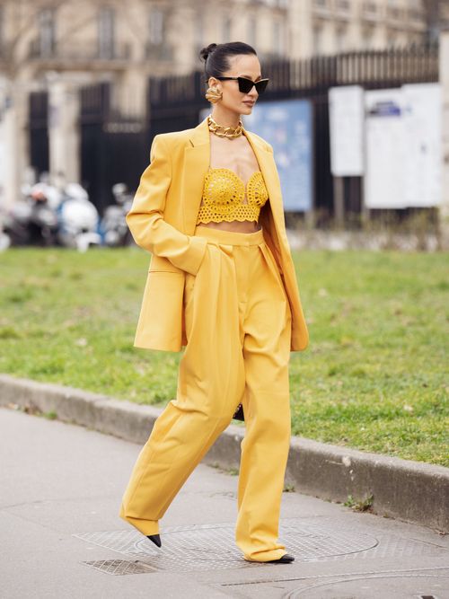 Anna Rosa Vitiello trägt ein gelbes Set mit passendem Spitzenbralette und Goldschmuck auf der Paris Fashion Week.