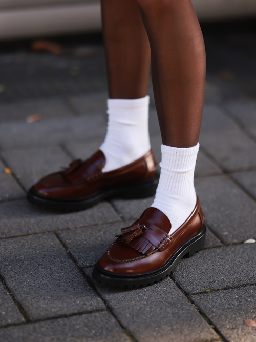 Detailaufnahme von Gina Walser in Köln, die weiße Sportsocken zu ihren Tasselloafers trägt.