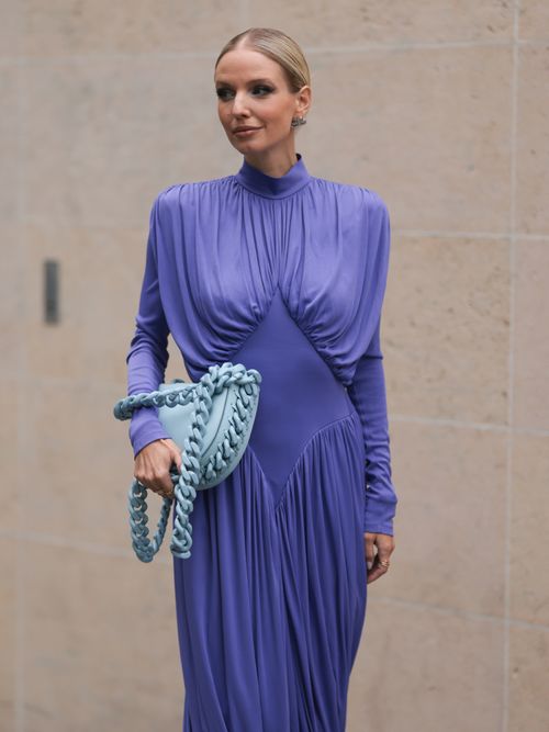 Leonie Hanne trägt ein lilafarbenes Kleid und eine Stella McCartney Tasche auf der Paris Fashion Week.