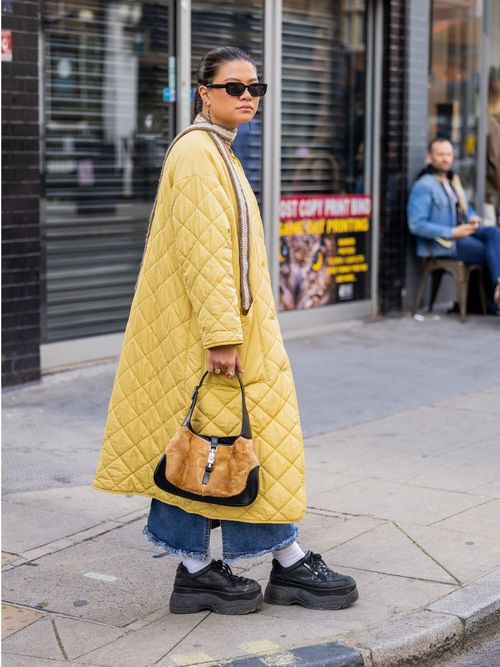 woman wearing sunglasses and yellow long quilted coat