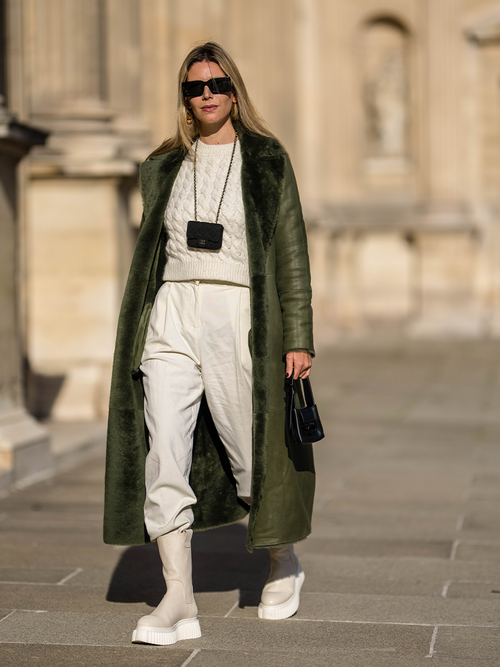 Streetstyle mit einer weißen Hose, Pullover und einem Flaschengrünen Mantel.