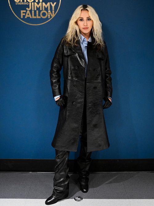 Miley Cyrus attends the Tonight Show with Jimmy Fallon wearing a black leather coat, matching leather trousers, a light blue button up shirt, and black leather shoes.