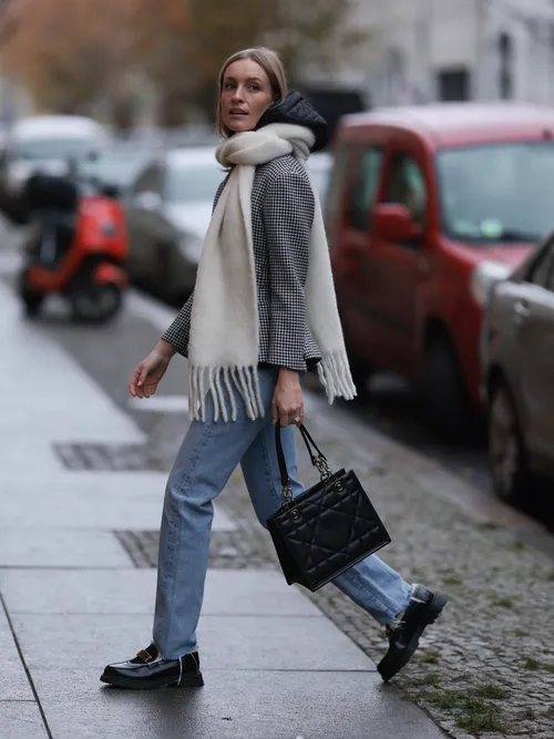 Guest wearing jeans with blazer and white scarf