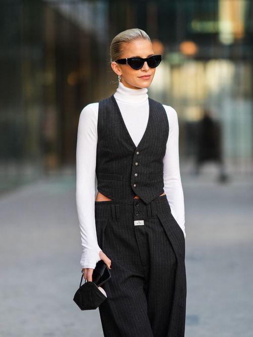 Caro Daur trägt eine Anzugweste mit einem weißen Rollkragenpulli und Sonnenbrille auf der Milan Fashion Week.