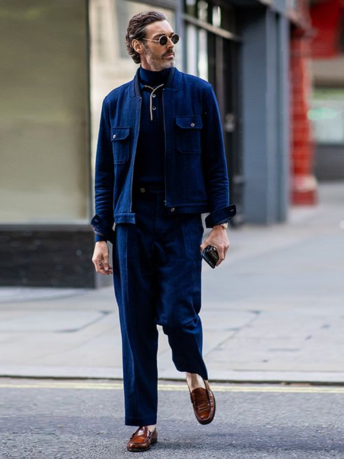 Street Style Look von der London Fashion Week, wo ein Gast ein blaues Ensemble mit braunen Loafer trägt.