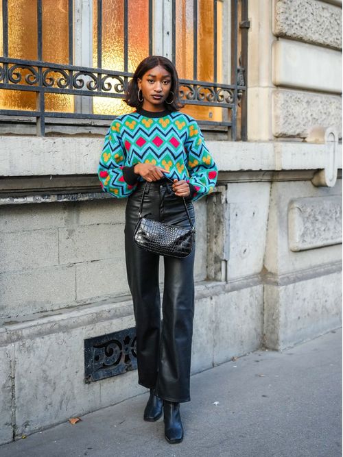 woman wearing black leather pants and green pattern sweater