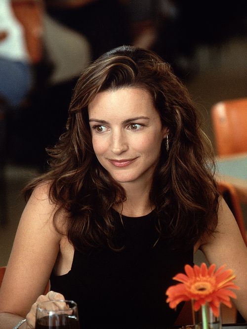 Kristin Davis mit wuscheligen Haaren und einer Blume