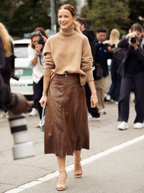 Victoria Magrath trägt einen beigen Rollkragenpullover mit einem braunen Lederrock auf der Milan Fashion Week.