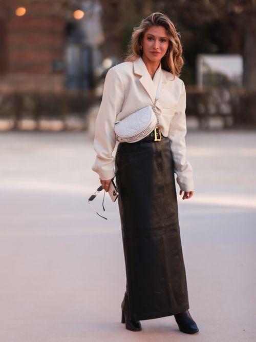 blonde woman wearing maxi dress with blue blazer and white handbag