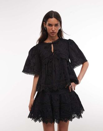 AllSaints Lillith - Blusa in pizzo nero a maniche corte con allacciatura