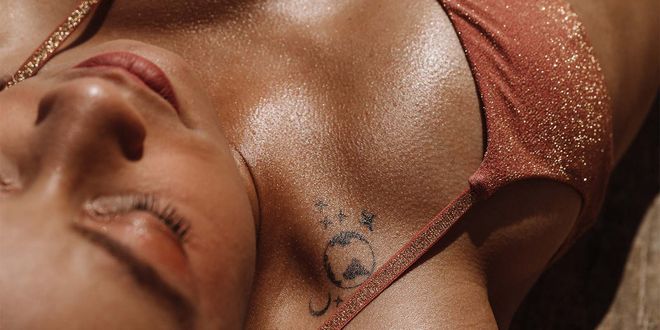 Frau am Strand beim Sonnenbaden in einem bronzefarbenen Bikini