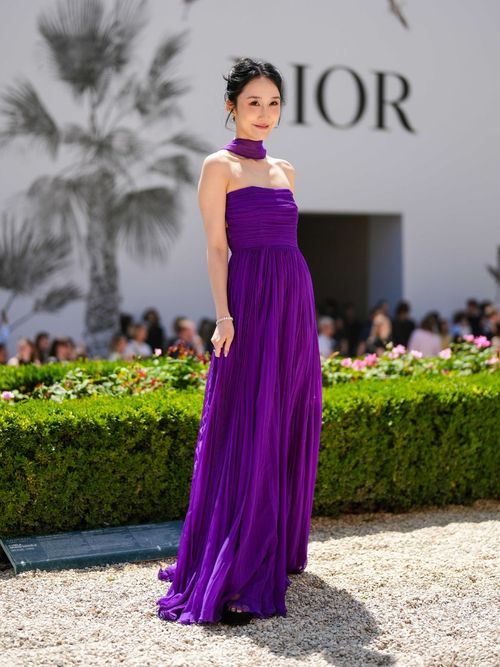 A guest wears a bright purple maxi dress