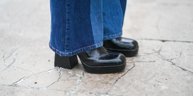 Close-up von einer weiten Jeans und schwarzen Plateauschuhen.