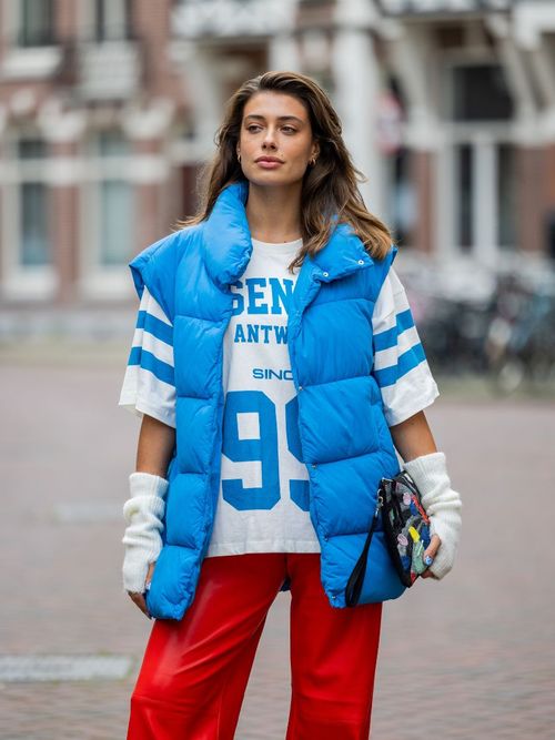 Talissa Benamou trägt ein blaues Puffer-Gilet, ein Spielertrikot T-shirt mit einer roten Hose und weißen Handschuhen aus Strick