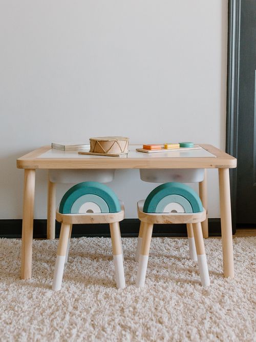 Kindertisch mit zwei Holzstühlen und einer Regenbogenlehne.