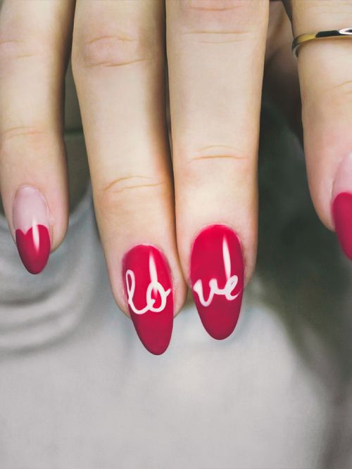 Finger mit rotem Nagellack in dem Love steht.
