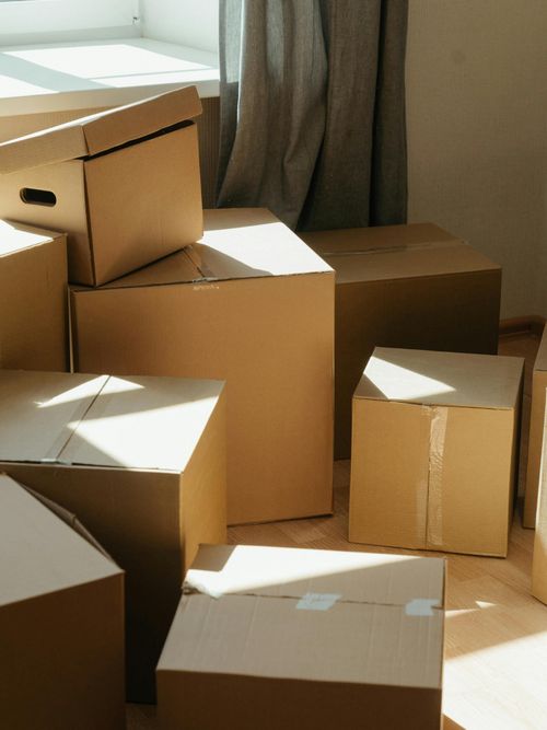 Umzugskartons in einer lichtdurchfluteten Wohnung gestapelt.