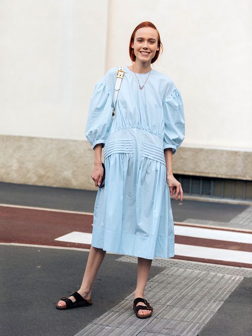 Model Kiki Willems mit einem blauen Kleid mit Puffärmeln und schwarzen Birkenstocks.
