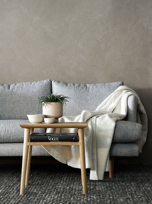 Graues Sofa vor einer beigen Wand.