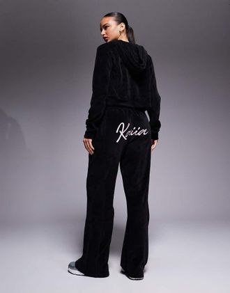 KAIIA Joggers a fondo ampio in velour color nero e rosa confetto con logo ricamato in coordinato-Multicolore