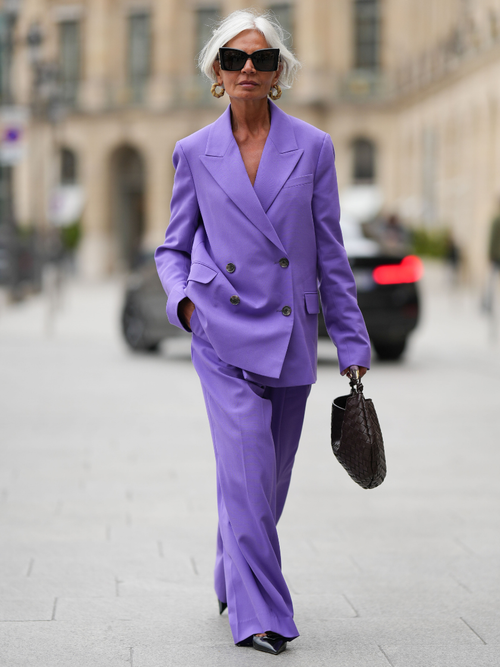 Grece Ghanem trägt einen fliederfarbenen Hosenanzug mit schwarzen Accessoires in Paris.