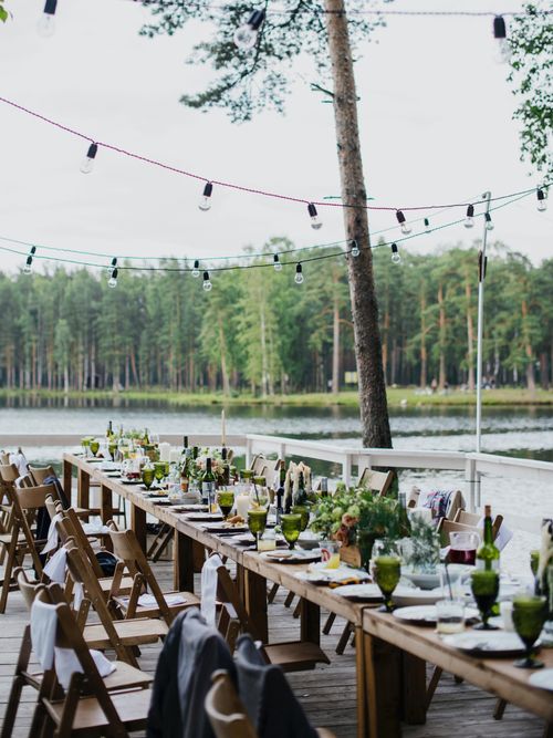 Sommerlich dekorierter Tisch im Freien bei einem See