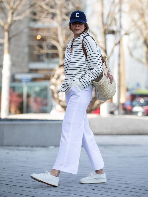 Streetstyle mit weißer Hose, Ringelpullover und Celine-Cap.