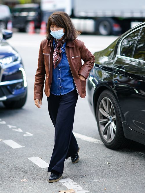 Streetstyle mit Jeanshemd, zur schwarzen Hose und braunen Lederjacke.