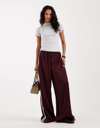 adidas Originals Pantaloni sportivi a fondo ampio in raso bordeaux e bianco sporco-Rosso