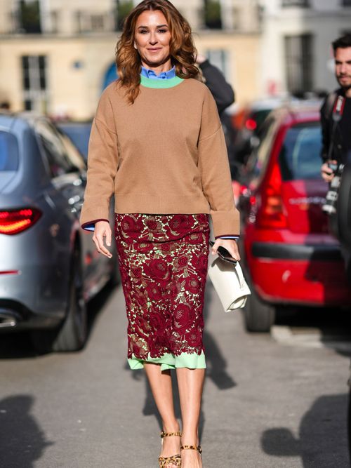 Street Style Look von der Paris Fashioin Week, wo ein Gast einen beigen Pulli, blaue Bluse und einen Rock aus Spitze.
