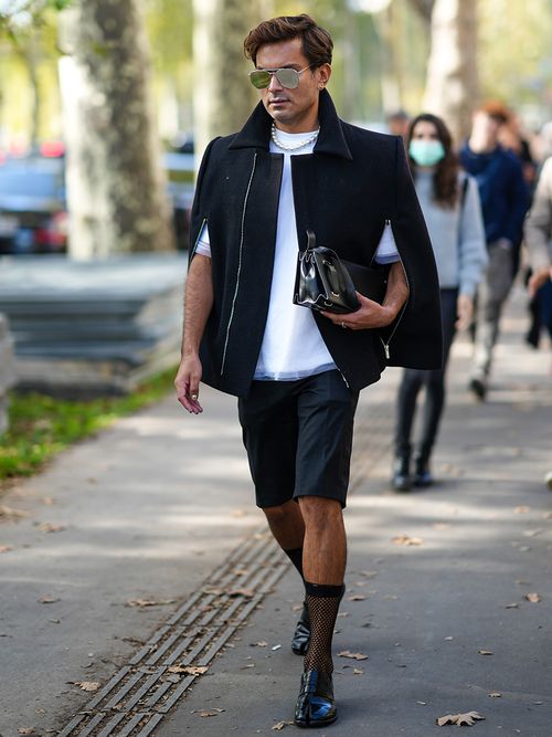 Street-Style-Look von einem Mann auf der Paris Fashion Week in einem schickem Outfit und enganliegender Bermudashorts
