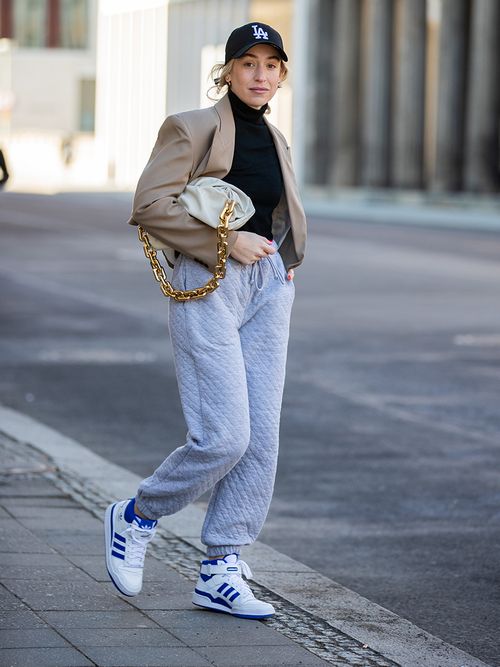 Sonia Lyson mit Sweatpants, Sneakers und einem New Era Baseball Cap.