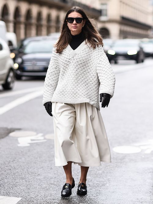 Streetstyle mit weißem Strickpullover und Culotte zu schwarzen Loafers.