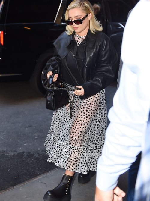 Florence Pugh is seen in New York City wearing black sunglasses, a cropped leather blazer, a tulle dress, and black platform boots.