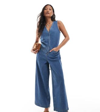 Asos Petite ASOS DESIGN Petite - Tuta jumpsuit ampia senza maniche in denim blu lavaggio medio