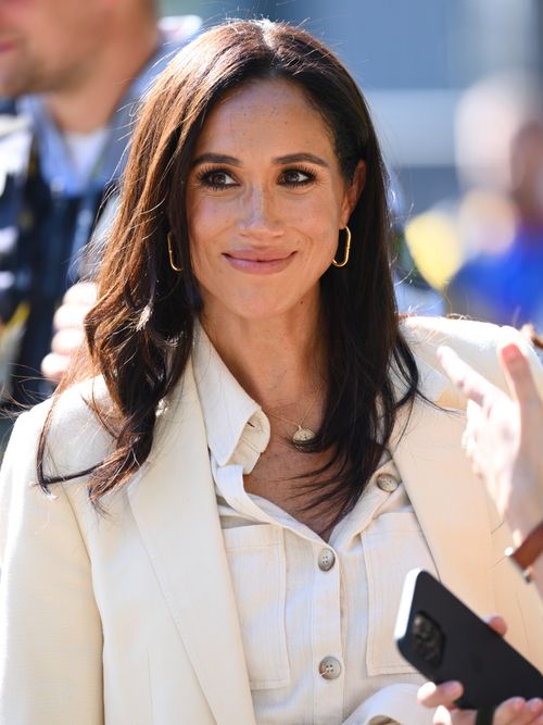 Meghan Markle trägt einen weißen Blazer mit weißer Bluse in Düsseldorf.