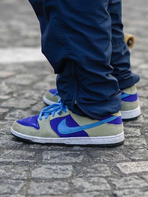 Close-up von blau-grauen Nike Sneakers und einer dunkelblauen Jeans.