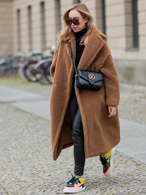 Sonia Lyson in einer Leder-Leggings und einem beigen Teddy-Coat.