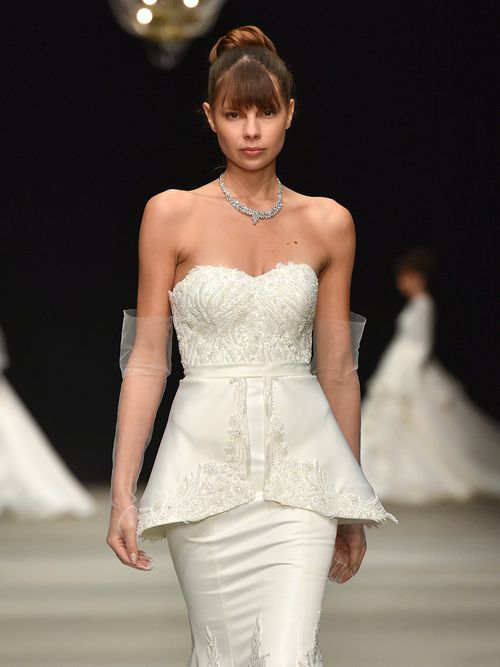 Braut auf dem Runway mit Schößchen und transparenten Handschuhen.