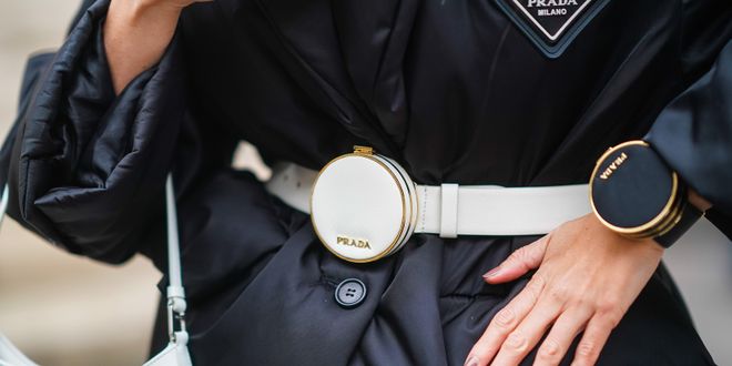 Close up von einer weißen Prada Gürteltasche und einer Mini-Prada Tasche fürs Handgelenk.