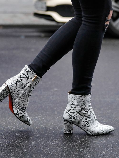 Close up mit einer schwarzen Skinny-Jeans und Ankle Boots in Schlangenleder-Optik.