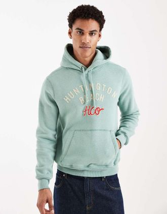Hollister Felpa con cappuccio verde con grafica Huntington Beach sul davanti