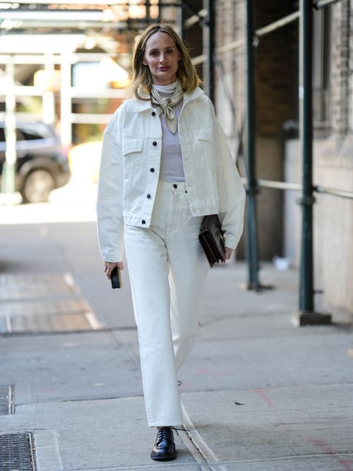 Lauren Santo Domingo trägt eine weiße Denimjacke und eine weiße Jeanshose mit schwarzen Boots, Rollkragen und Halstuch auf der New York Fashion Week.