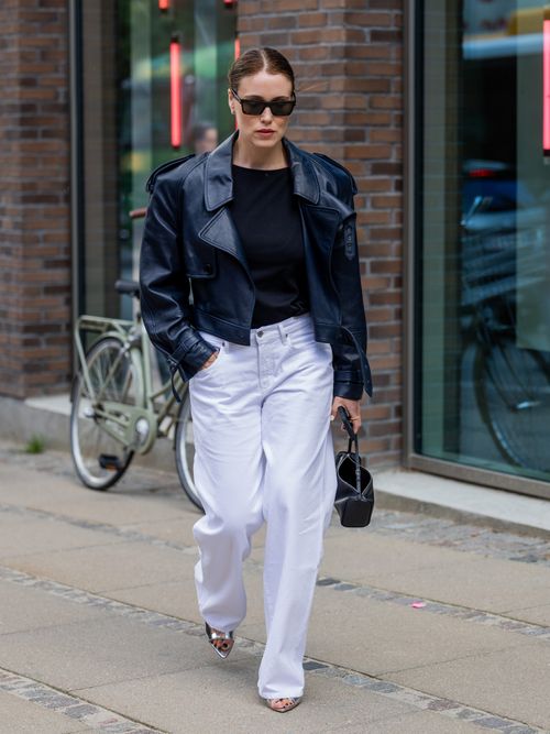 Annabel Rosendahl trägt eine schwarze Lederjacke mit schwarzem T-Shirt und hellblauer Jeanshose auf der Copenhagen Fashion Week.