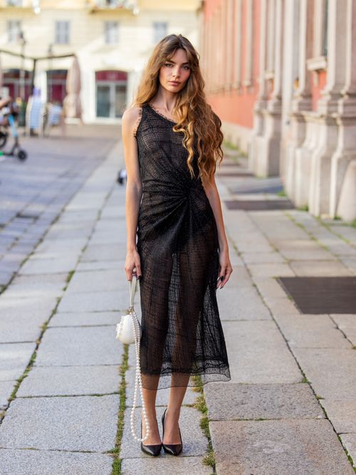 Mara Lafontan trägt ein schwarzes transparentes Kleid mit weißer Perlentasche in Mailand.