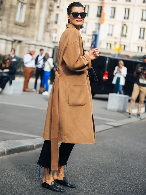 Streetstyle mit einem Camelcoat, einer schwarzen Hose und schwarzen Loafers.