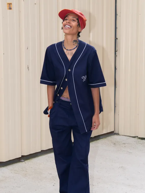 Kai-Isaiah Jamal is wearing a blue short-sleeve shirt by Wales Bonner coordinated with matching trousers, a red hat, and Adidas shoes outside Wales Bonner show during the Haute Menswear Spring/Summer 2025 as part of Paris Fashion Week on June 19, 2024 in Paris, France.