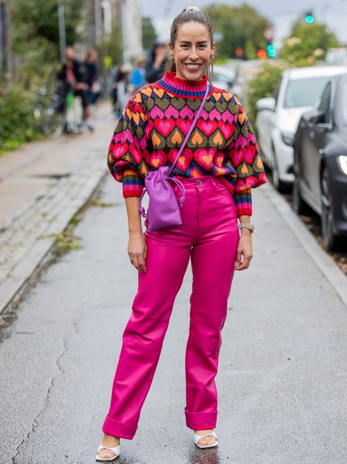 Idalia Salsamendi trägt einen bunten Strickpullover und eine pinke Lederhose auf der Copenhagen Fashion Week.