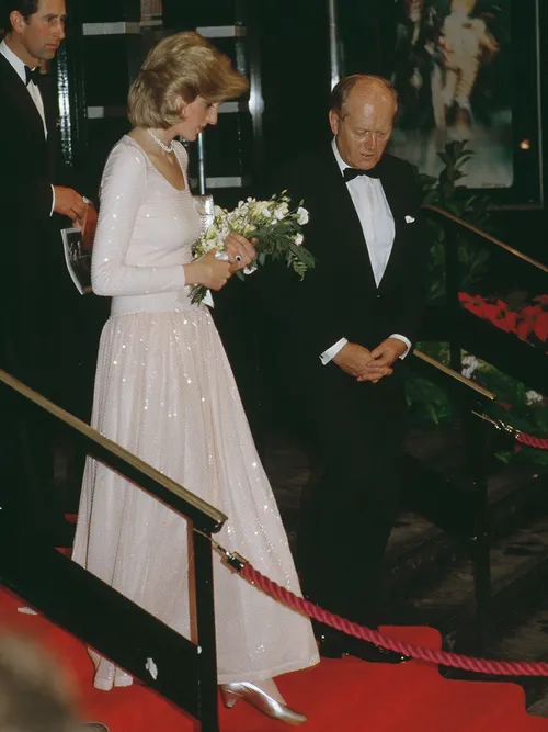 Pinzessin Diana in einem weißen Glitzerkleid mit langen Ärmeln.