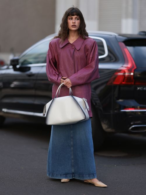 A guest wears a purple leather jacket with a jean skirt
